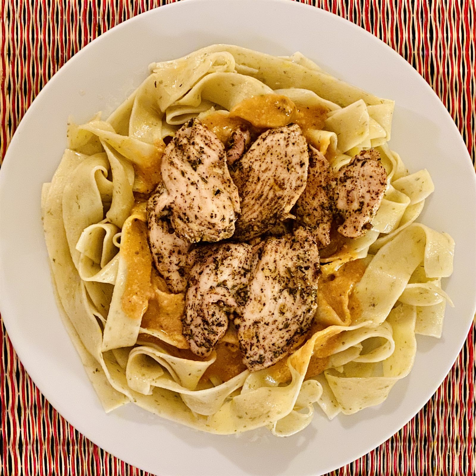 Seared chicken over pappardelle in a rich sauce
