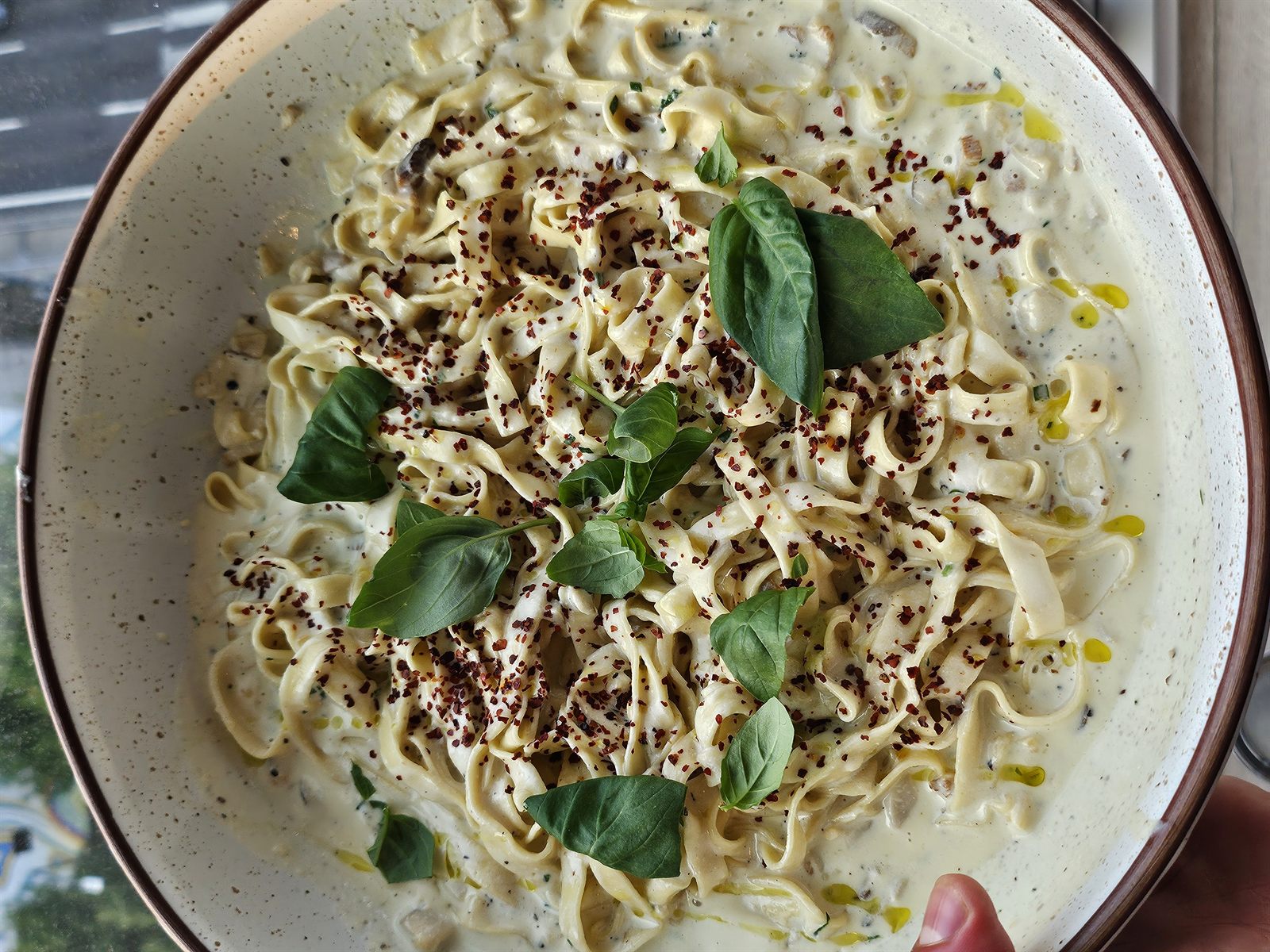 Fresh pasta in a creamy sauce with basil, chili flakes and olive oil