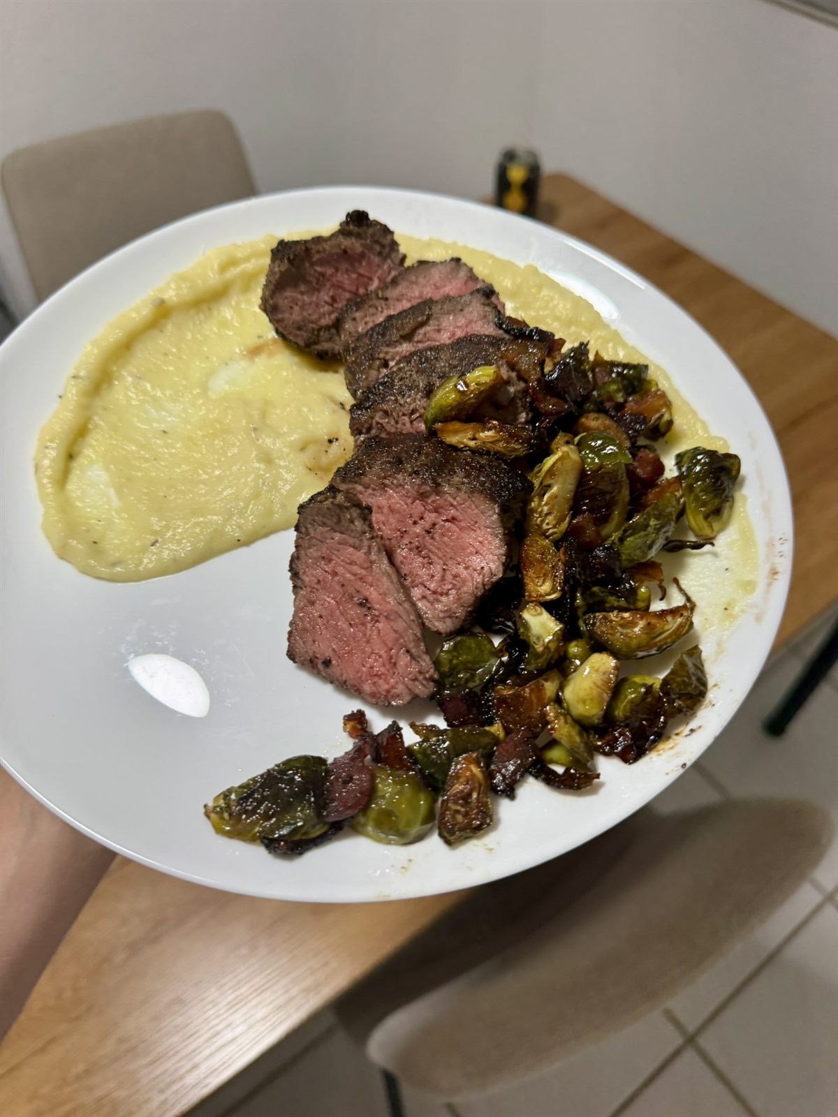 Sliced steak over polenta with roasted brussels sprouts