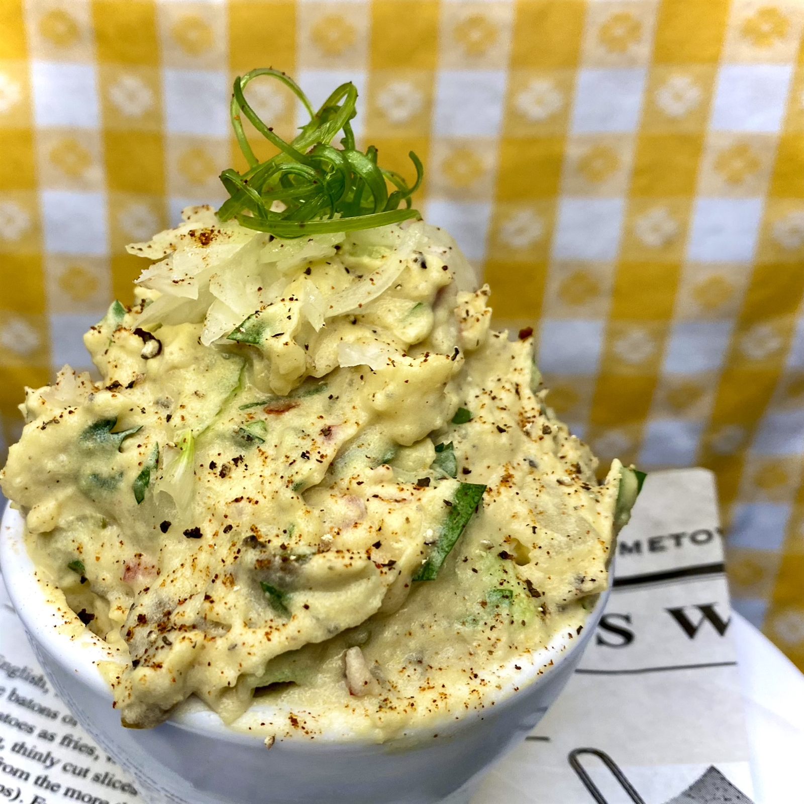 Creamy whipped salad in a bowl garnished with scallion and black pepper