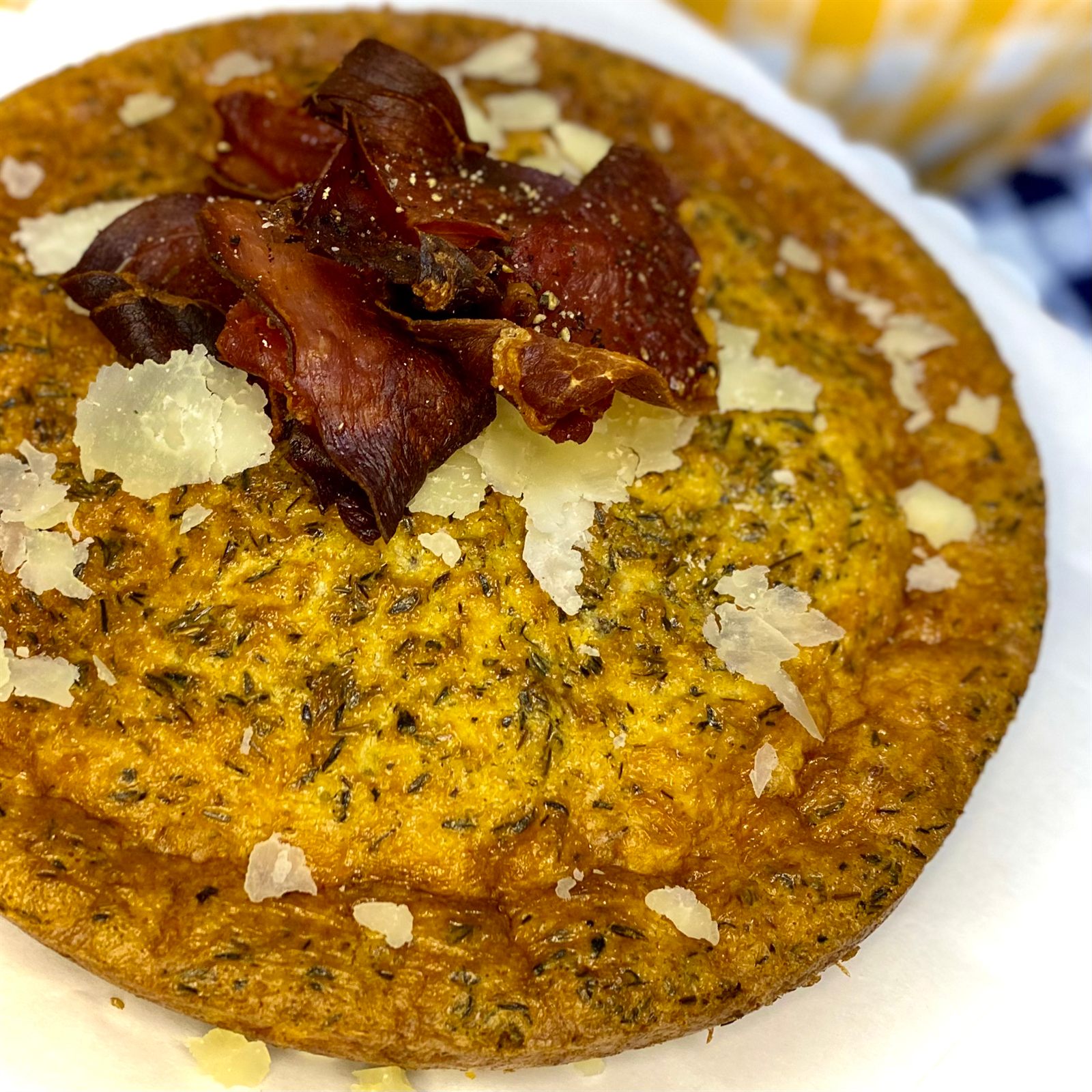 Golden baked dish topped with crisped ham and shaved cheese